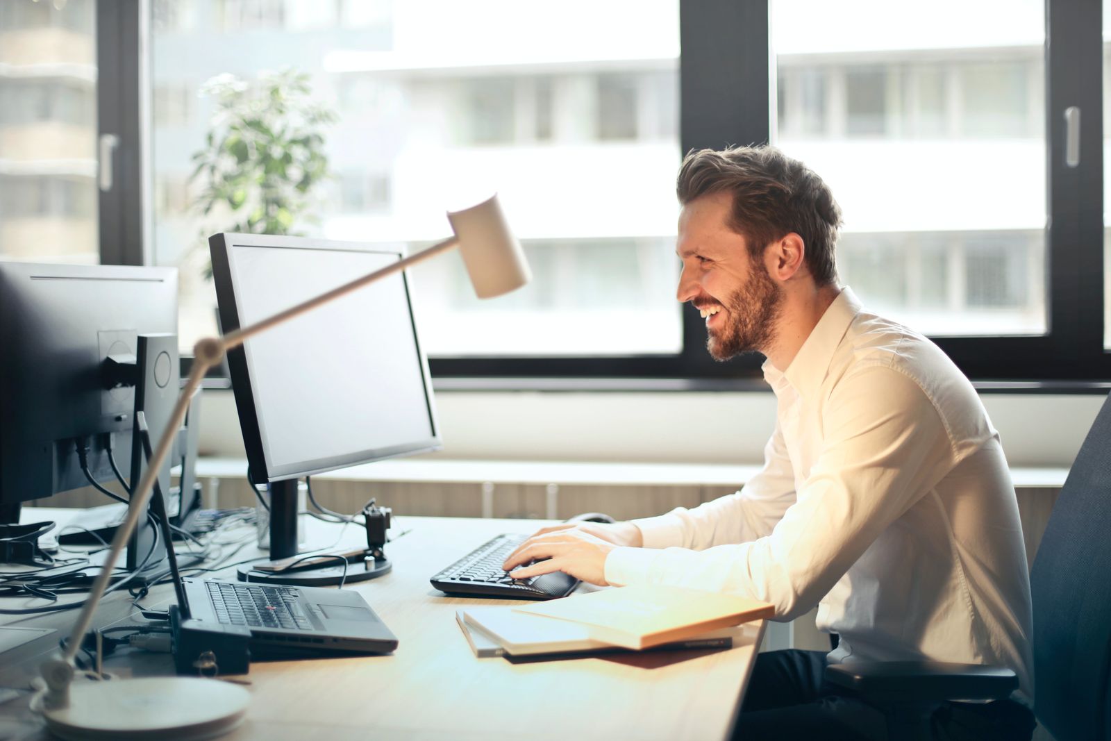 An IT specialist smiling while working at a computer